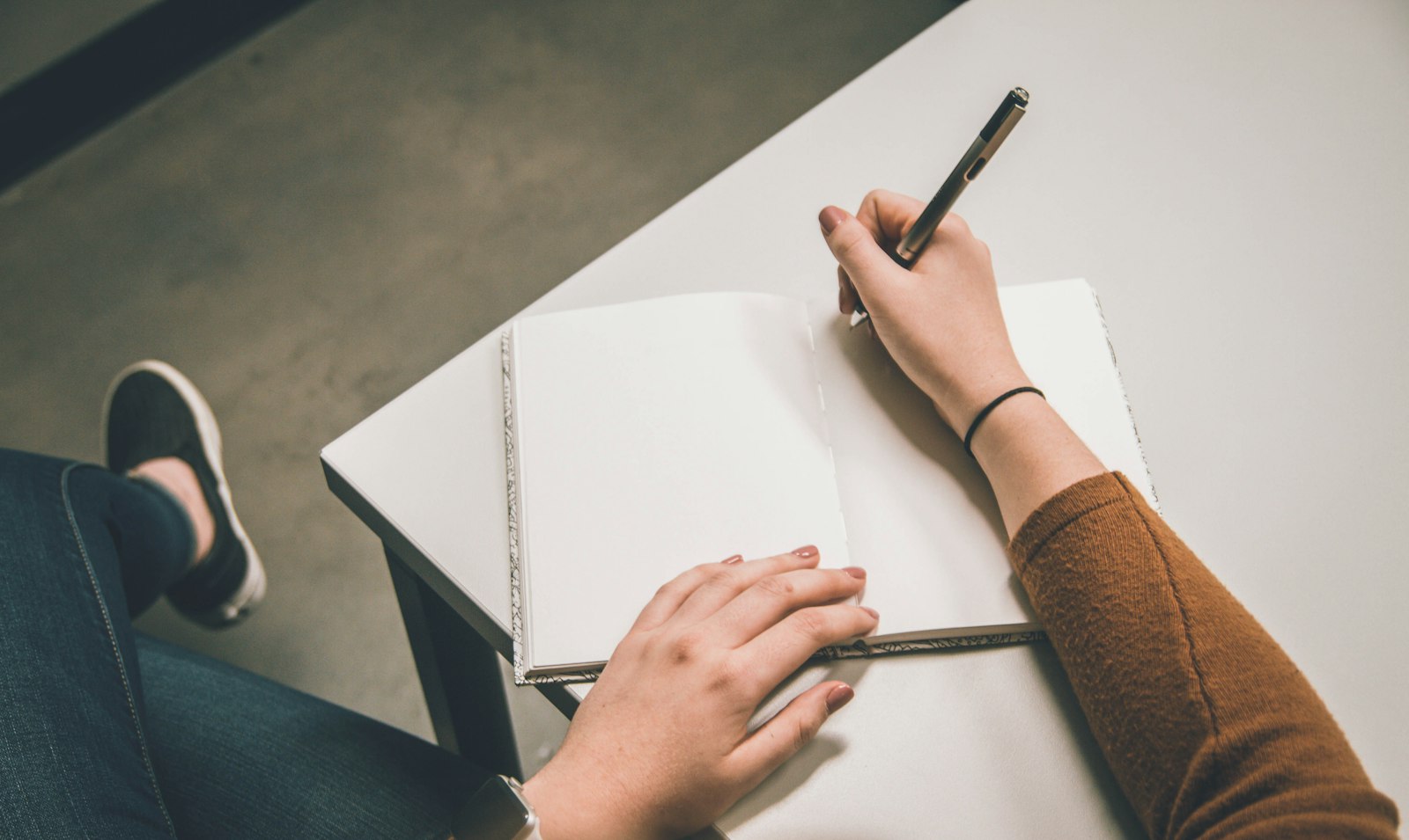 A person writing on white paper